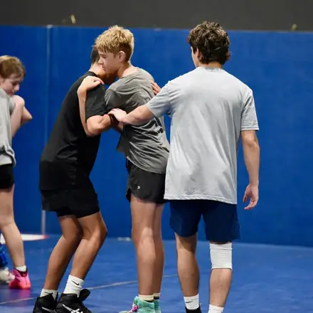 Three AWC wrestlers working a stand-up position during practice.