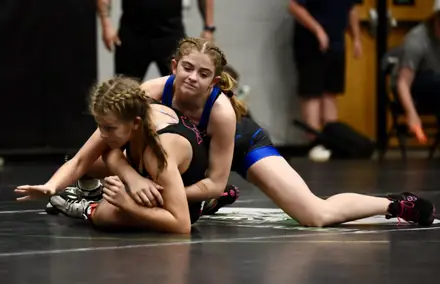 Two girls battle for position on the competition mat