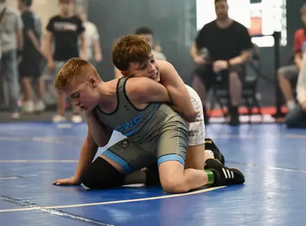 A wrestler works for a turn from the top position during a match