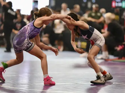 Two girls face off in a neutral stance during a tournament match