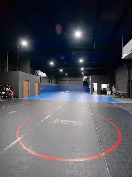 The mat room seen from the corner, wrestling circle in the foreground.