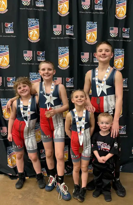 A group of AWC girls with their tournament medals at the awards backdrop