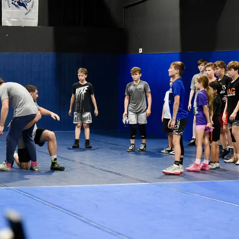 Young AWC wrestlers spread out on the mat during a warm-up.