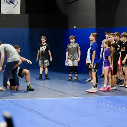 Young AWC wrestlers spread out on the mat during a warm-up.