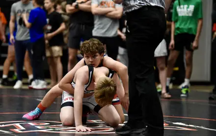An AWC wrestler works on top as the official watches for the pin