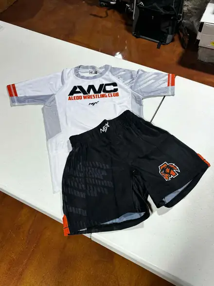 The white AWC competition shirt and club shorts laid out