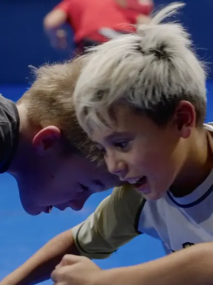 Two young wrestlers listening closely during instruction.