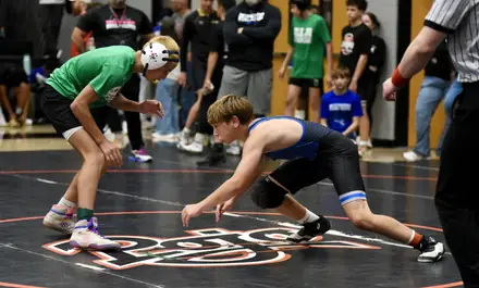 Two young wrestlers set up their shots in the middle of the mat