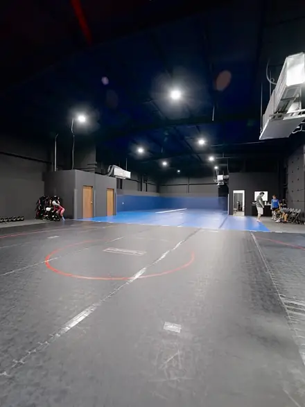 A wide view of the training floor with the wrestling circle marked in red.
