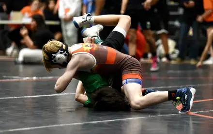 Youth wrestlers tangled up in a scramble during a tournament bout