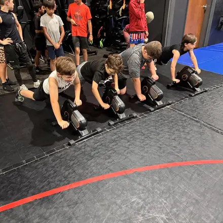 Athletes working through a sled push interval in the training bay.