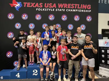The AWC team and coaches on the podium at the Texas USA Wrestling Folkstyle State Championship
