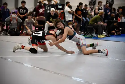 Two youth wrestlers scramble for control during a tournament bout
