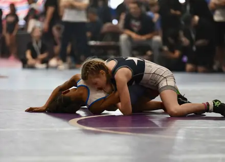 A girl works from the top position during a tournament match