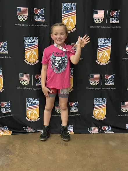 A young club member at the awards backdrop after a tournament