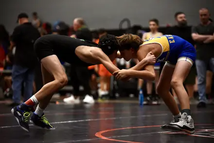 Two wrestlers hand fight from a neutral stance at a Texas tournament