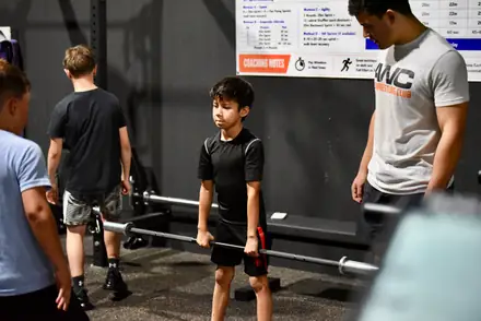 Young wrestlers working through a lift at the rack during strength and conditioning