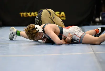 An AWC wrestler works to turn an opponent at a Texas USA Wrestling tournament