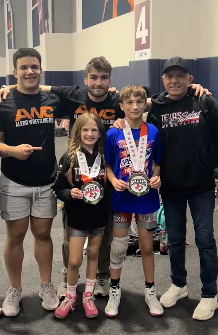 AWC wrestlers and coaches together with their medals after a tournament