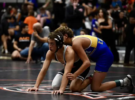 Two wrestlers battle from the down position during a tournament match