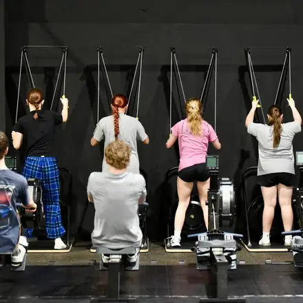 Athletes pulling on cable machines during an AWC strength session.