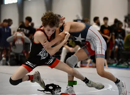 An AWC wrestler squares up against an opponent in a Texas flag singlet