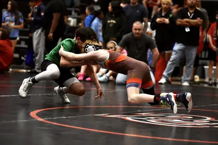 Two wrestlers battle through a takedown attempt during a match