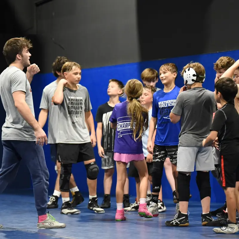 A group of AWC wrestlers hand fighting during a partner drill.