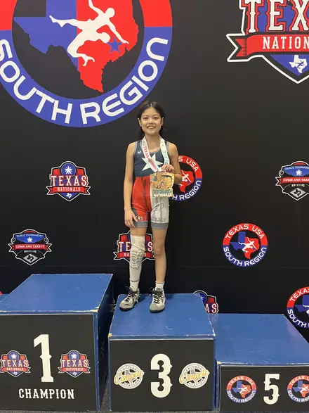 An AWC wrestler on top of the podium at the South Region championships