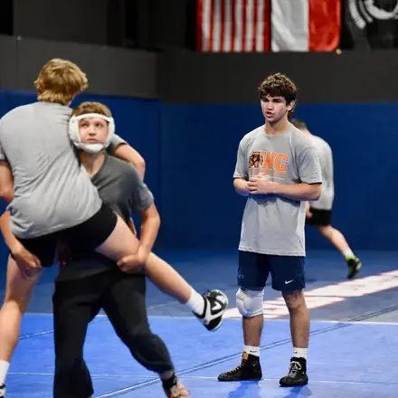 An AWC wrestler lifting a partner off the mat during a live round.
