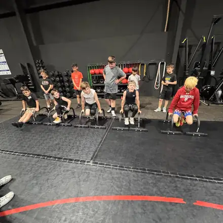 A circuit of AWC athletes moving between stations in the weight room.