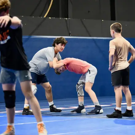 An AWC athlete finishing a low single leg attack in practice.