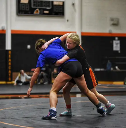 Two wrestlers battle for a takedown during a match