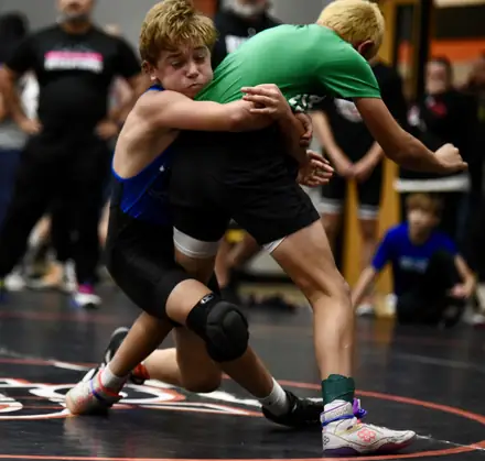 Two wrestlers grapple through a takedown attempt during a match