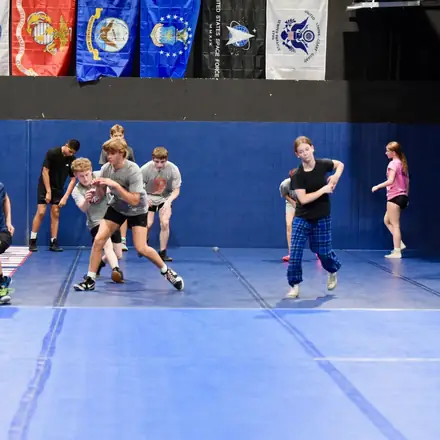 A busy AWC practice with several pairs wrestling live at once.