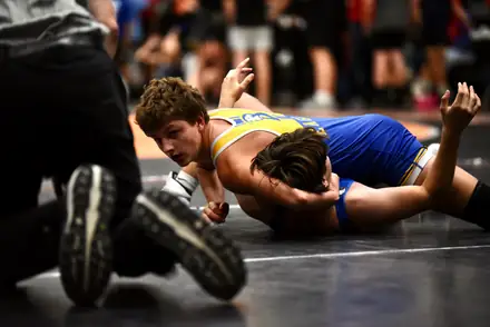 Two wrestlers scramble for control during a hard-fought bout