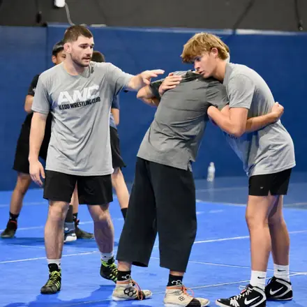 Two AWC athletes hand fighting from a collar tie during a live round.