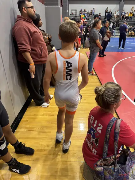 An AWC wrestler warming up at the edge of the mat before a tournament match