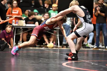 Two wrestlers reach for control in an open stance at a Texas tournament