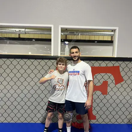 A coach with a young AWC wrestler in the training room.